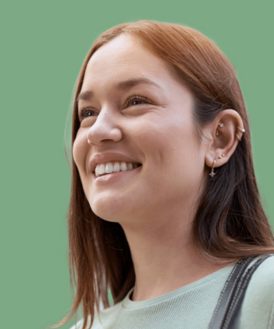 Smiling young woman with reddish-brown hair and earrings, representing the compassionate approach of MedPsych Health in mental health care services.