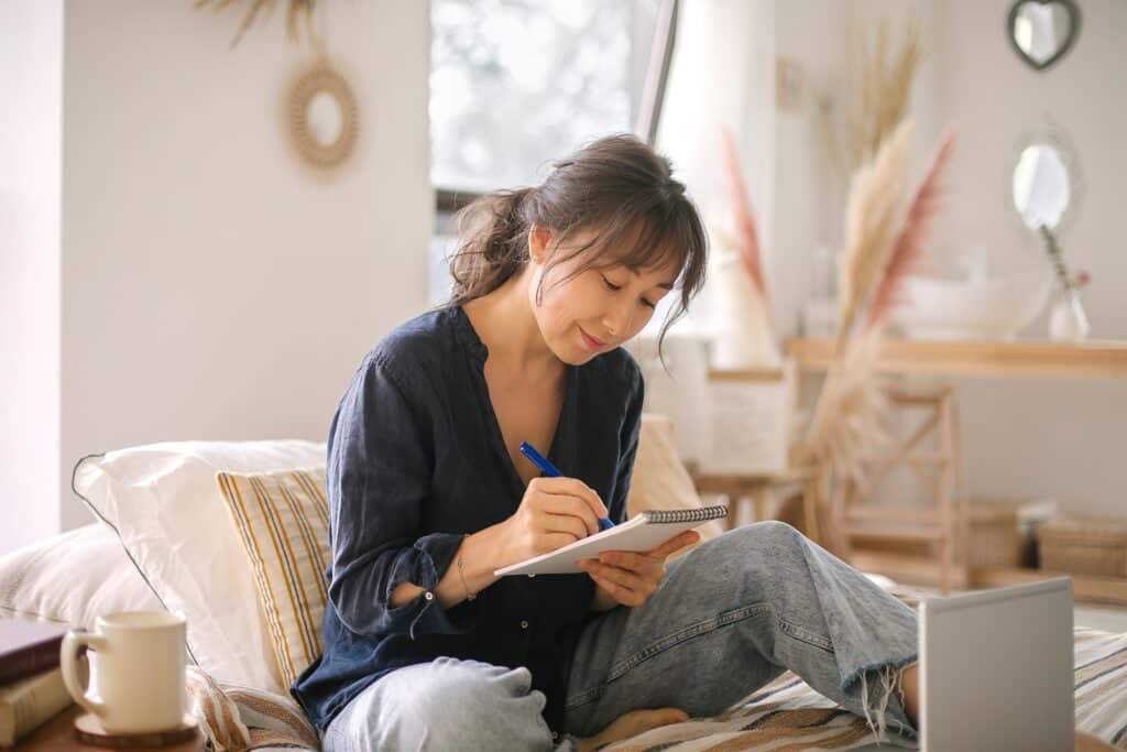 woman writing on notepad