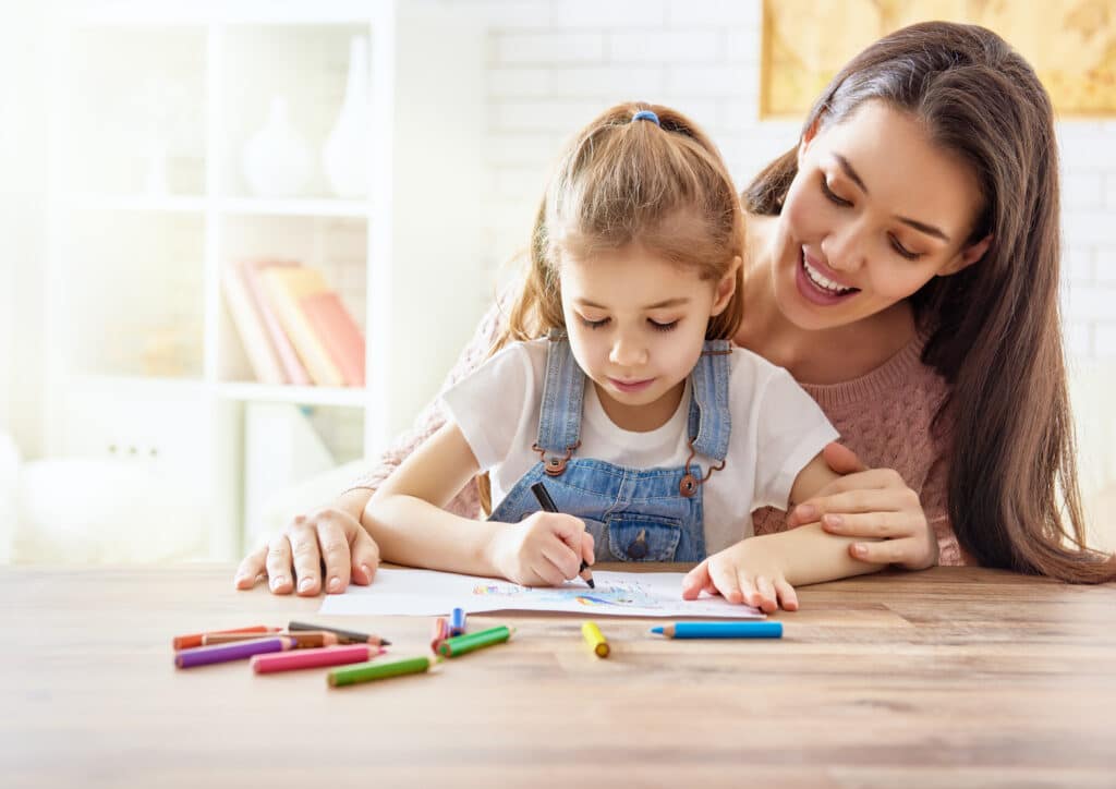 mother helping daughter color